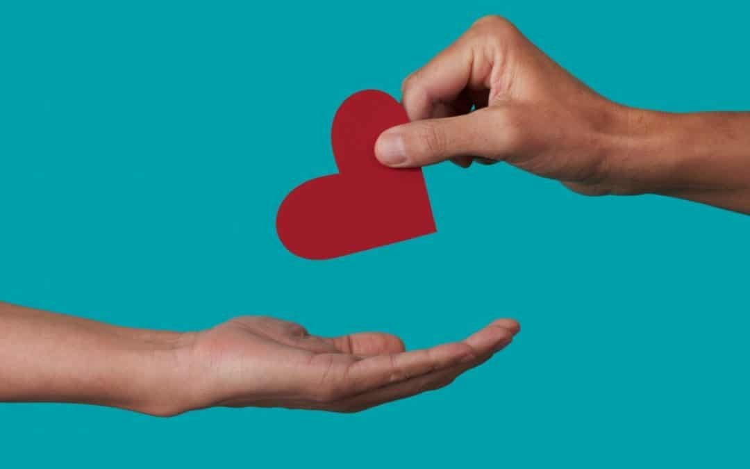 My charitable giving journey | One hand giving a heart to another hand