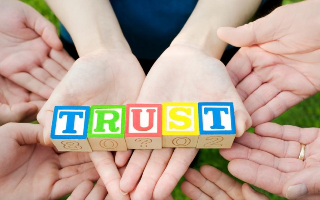Charitable Lead Trust: Several hands holding colored blocks that spell trust